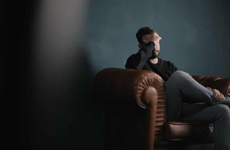 Man in pain sitting on couch